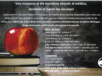 Apple sitting on books with vaccine information in Spanish